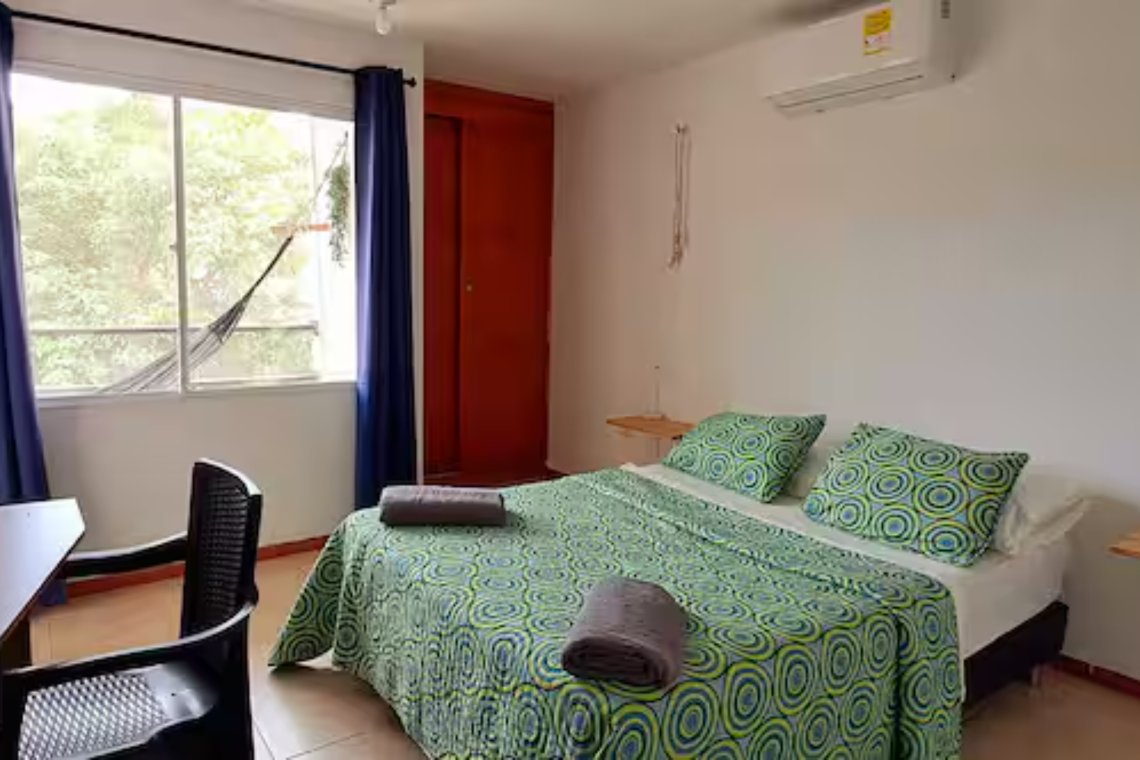 Image showing a comfortable room with a bed whose bedspread is green and is very soft.